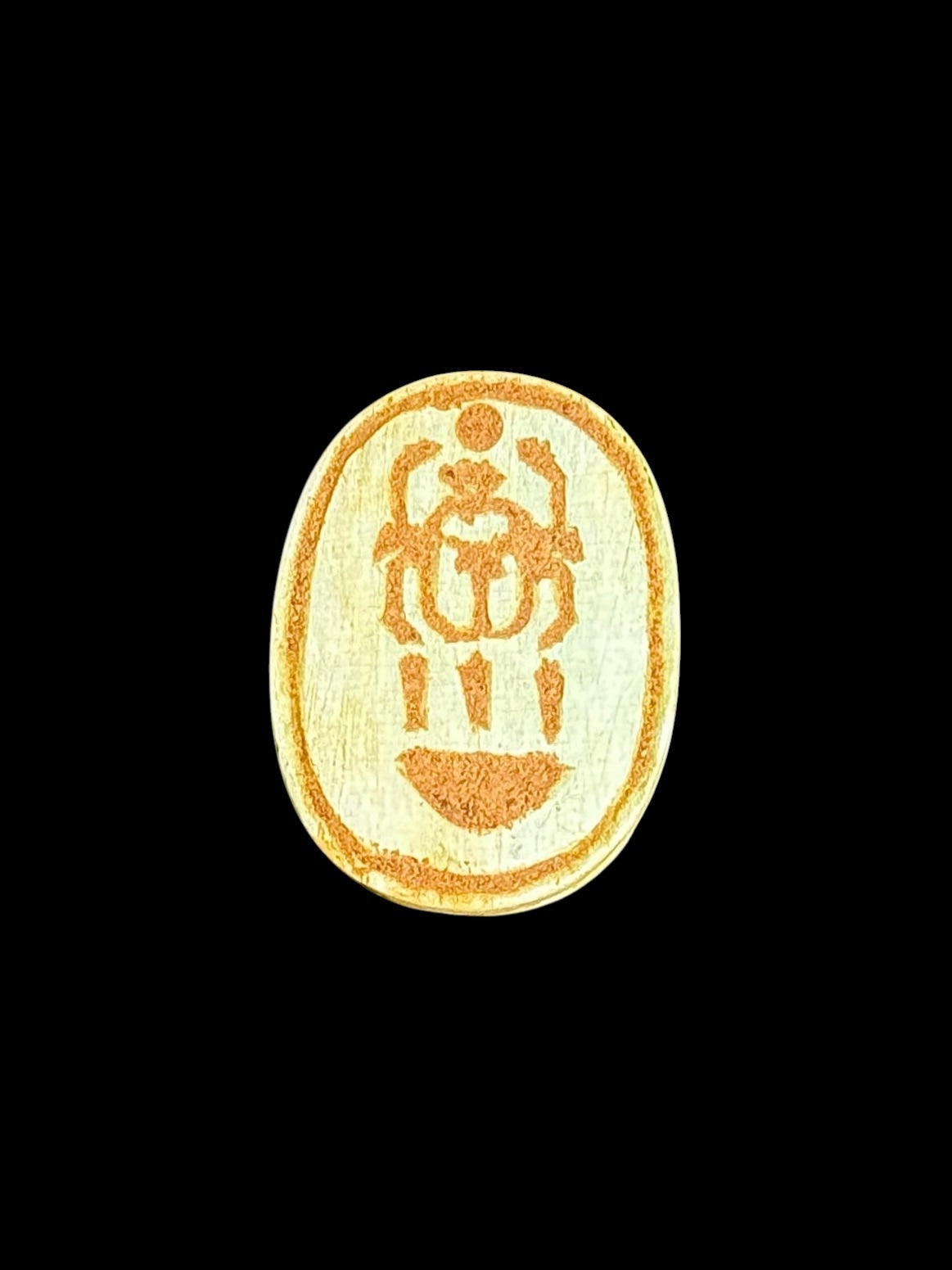 Underside of Egyptian scarab SC-120, showing pale underside with an ochre beetle-shaped motif inside an oval border.