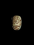 Top view of Egyptian scarab SC-110, showing dark brown and cream tones with pale green patches and markings across the upper surface.
