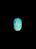 Top view of a turquoise-coloured stone scarab with incised beetle details, pale patches and tan accents against a black background.