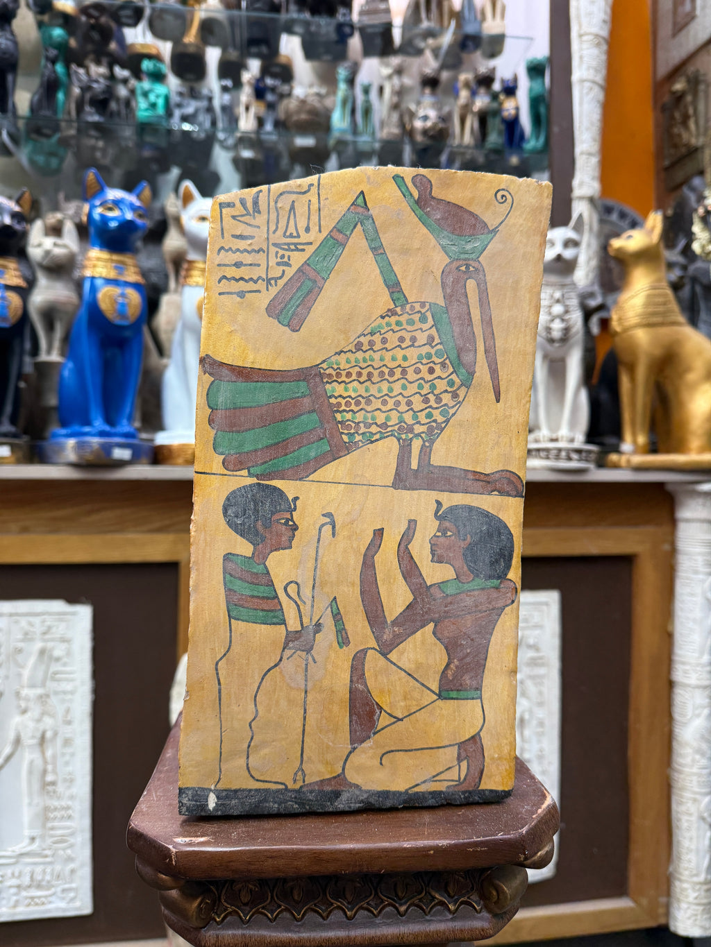 Close view of the Offering to Thoth wood plaque, with an ibis-headed figure above a smaller ritual scene on an ochre background.