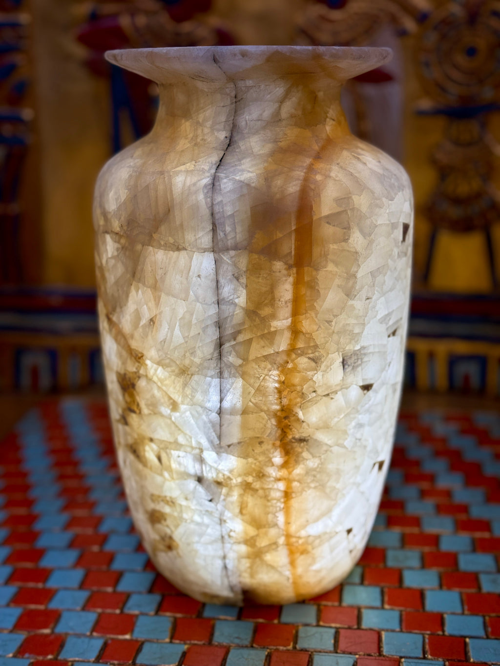 Tall cream and amber-banded alabaster vase with a slender smoky line and flared rim — illuminated view.