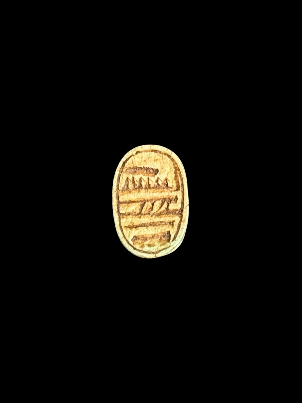 Underside of Egyptian scarab SC-060, showing ochre-toned underside with markings arranged in horizontal bands.