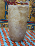 Slender cylindrical alabaster vase with layered cream, taupe and honey-coloured stone — unlit full view.