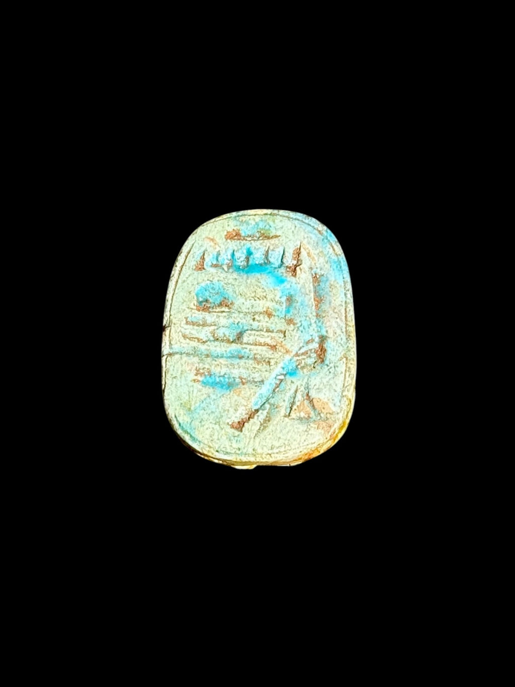 Underside of Egyptian scarab SC-104, showing pale green and blue underside with fine incised markings.