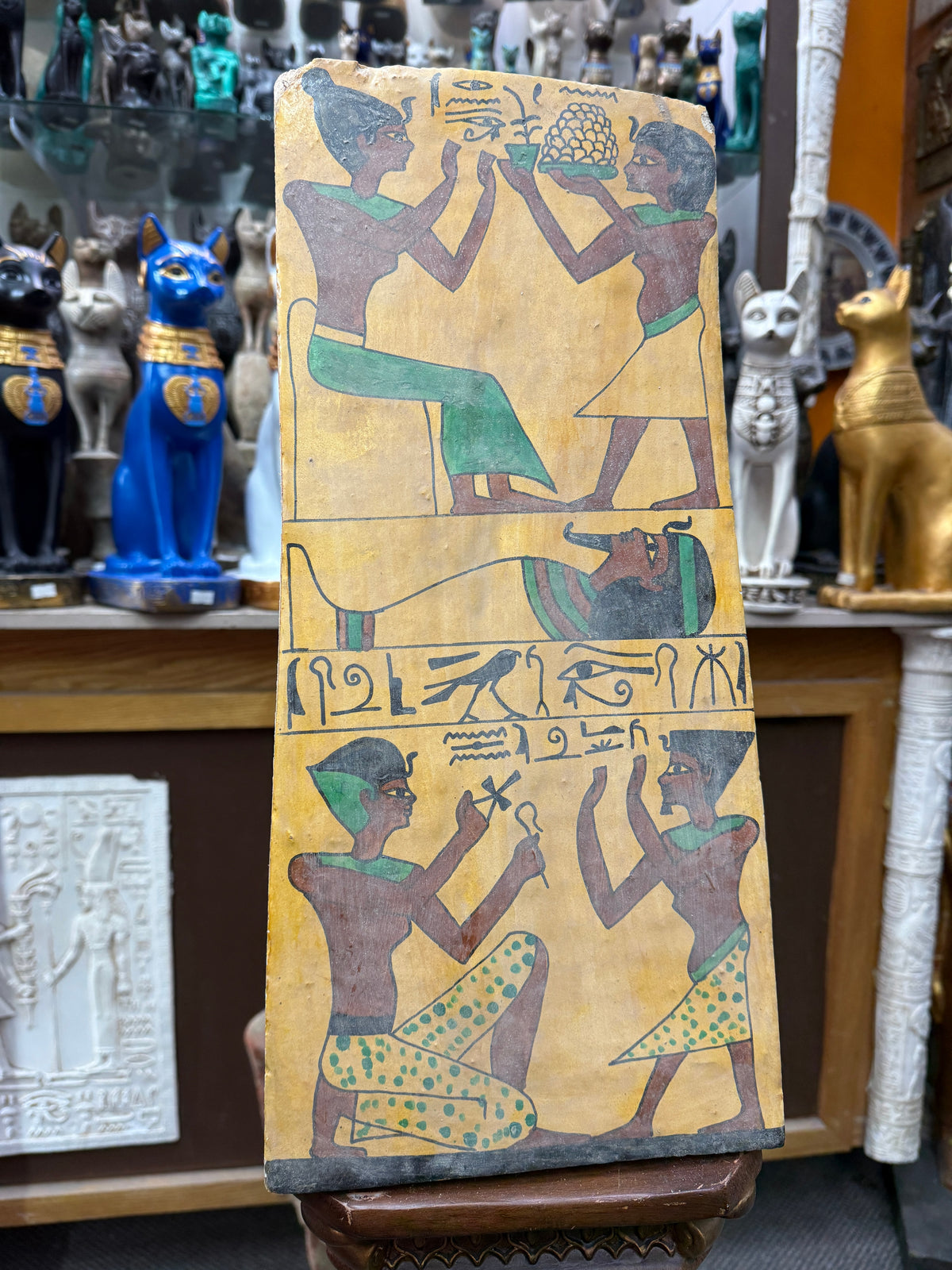 Close front view of the second Book of the Dead wood plaque, showing an offering scene, a horizontal wrapped figure and ritual figures below.