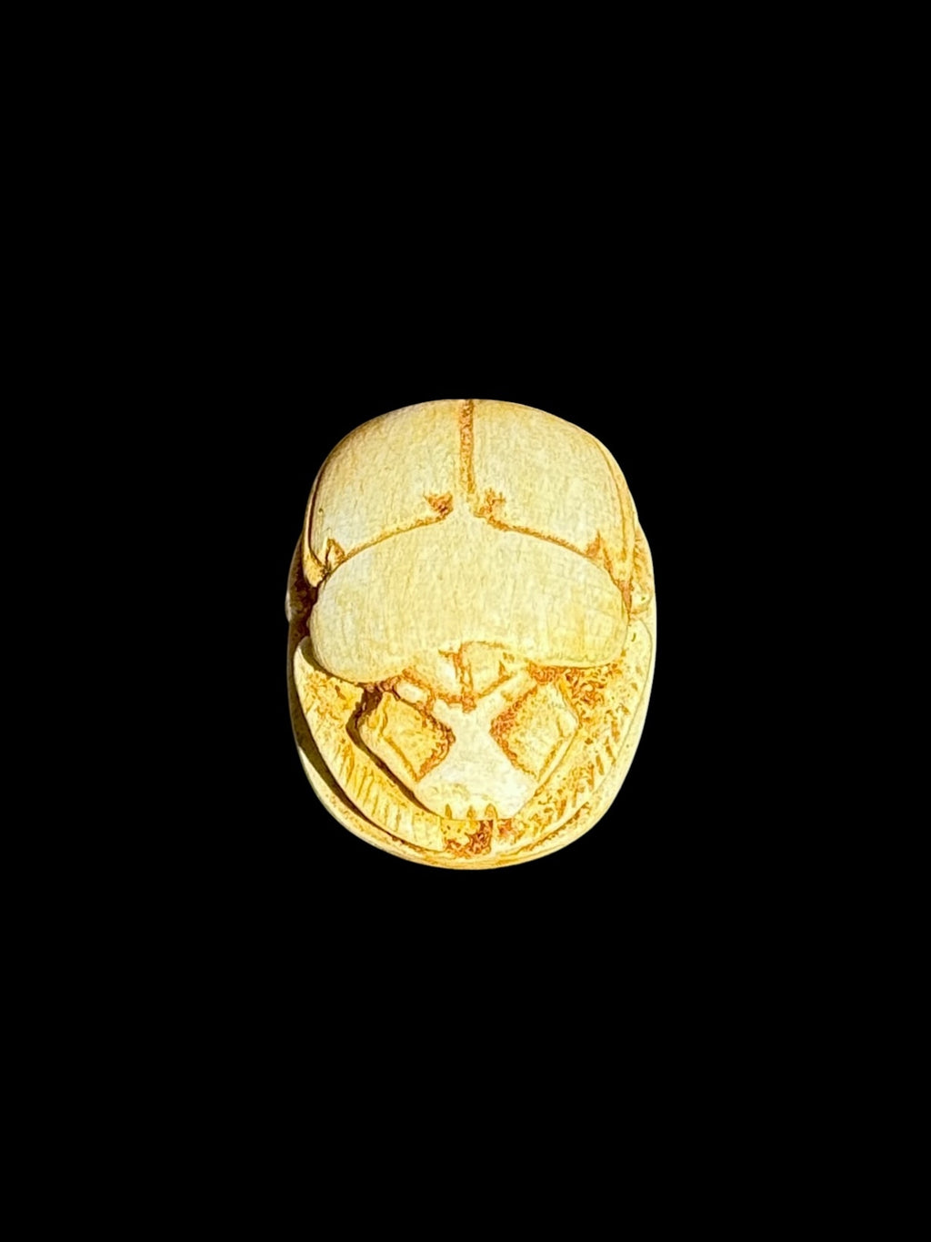 Top view of Egyptian scarab SC-103, showing warm cream and golden tones.