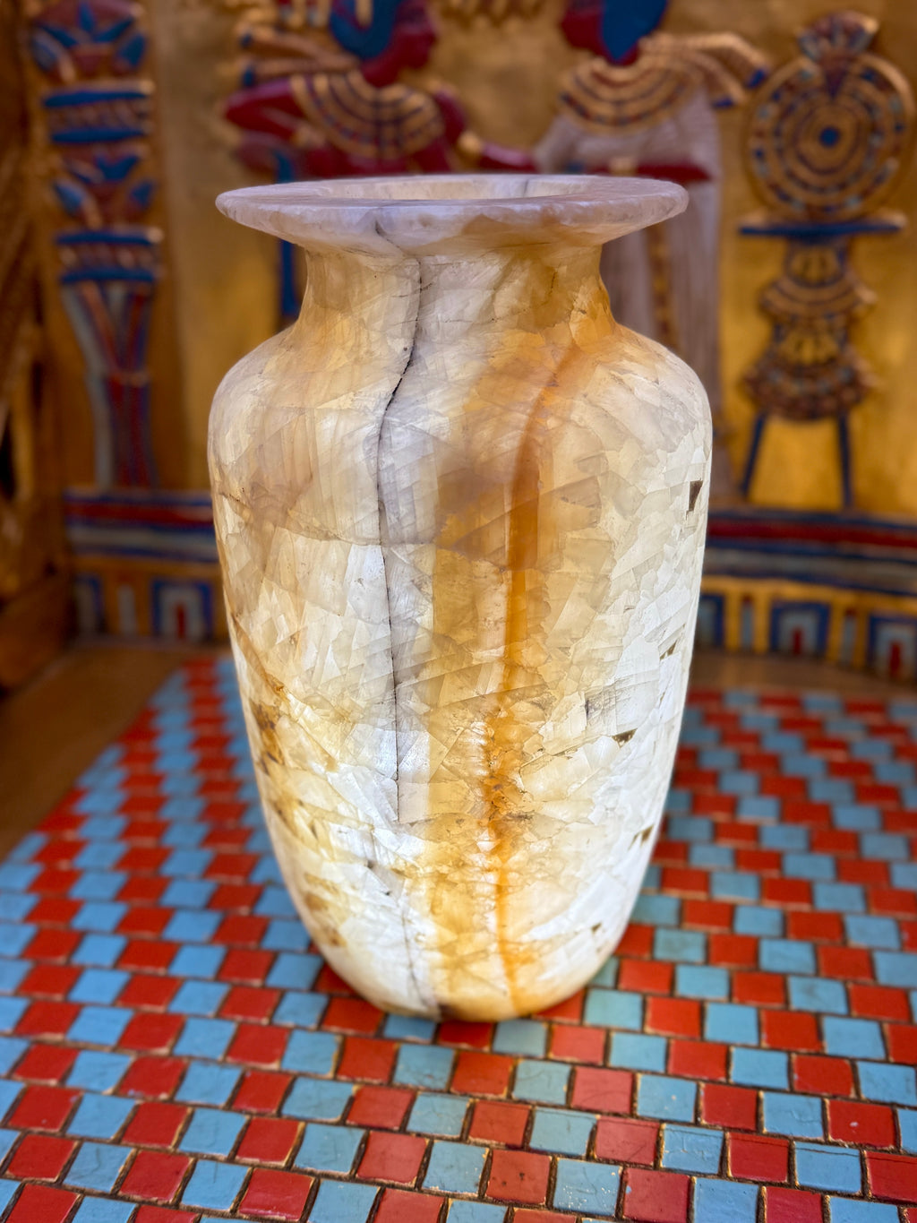 Tall cream and amber-banded alabaster vase with a slender smoky line and flared rim — illuminated view.