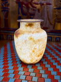 Slender cream alabaster vase with warm flowing veins, rounded shoulders and a flared rim — full view.