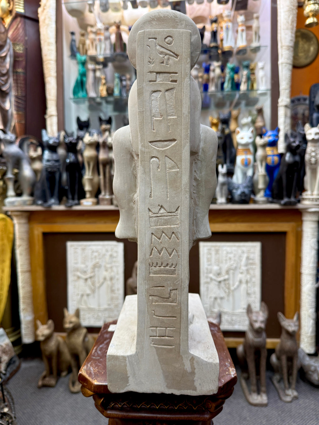 Rear view of Sekhmet statue showing a vertical column of hieroglyphic markings on the back pillar above the rectangular base.