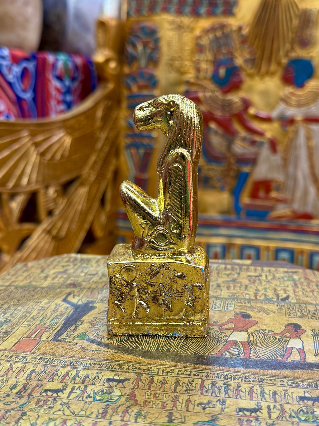 Side view of the gold finish Taweret kneeling statue with hippopotamus features and decorated square base.