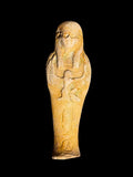 Front view of a sandy yellow and cream Egyptian stone figurine with a long headdress and winged Isis depicted across the front.