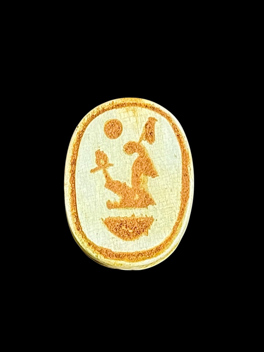 Underside of Egyptian scarab SC-101, showing pale underside with ochre figures and a curved motif.