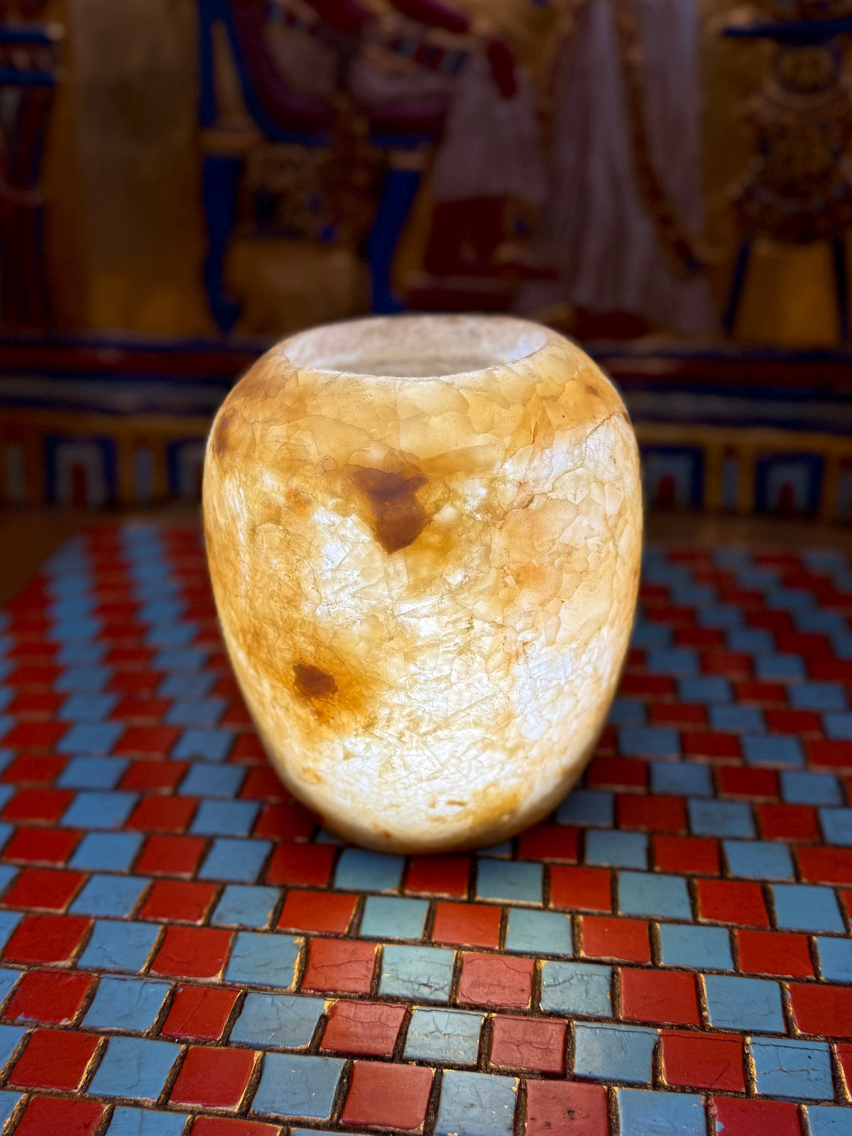 Small rounded alabaster vase with cloudy cream areas, honey-coloured patches and fine veining — full view.