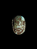 Top view of Egyptian scarab SC-113, showing dark brown and cream tones with turquoise patches and markings across the upper surface.
