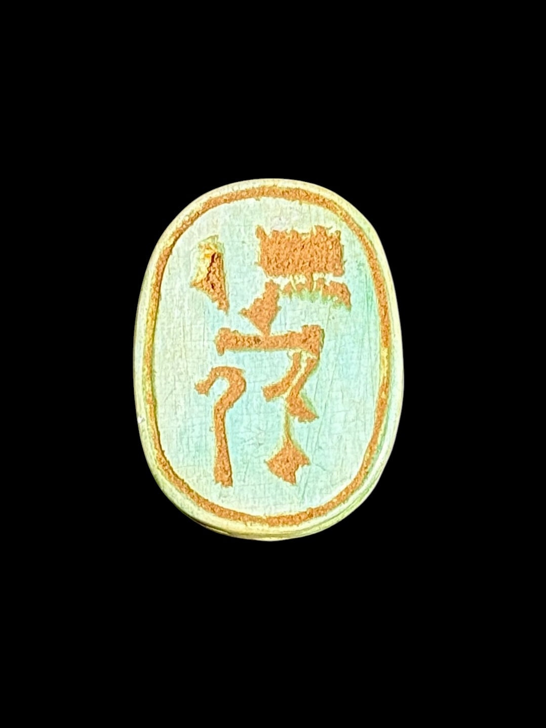 Underside of Egyptian scarab SC-097, showing pale turquoise underside with ochre markings inside an oval border.