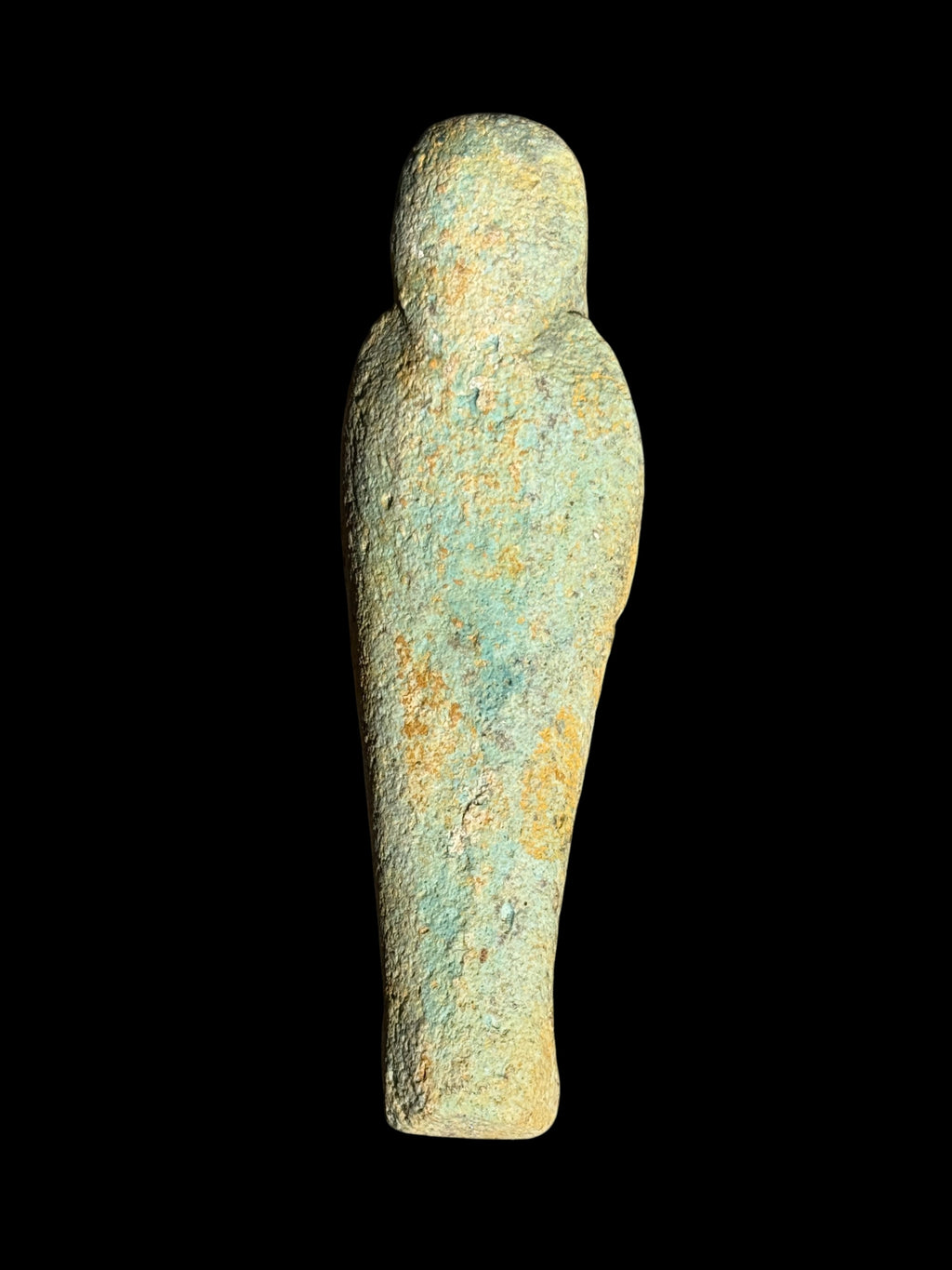 Back view of an Egyptian stone figurine with winged Isis showing its rounded head, broad shoulders and tapered body with mottled blue-green and sandy yellow colouring.