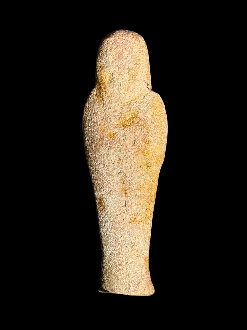 Back view of the Egyptian stone figurine with winged Isis showing a largely plain, textured cream and yellow surface, rounded head and tapered body.