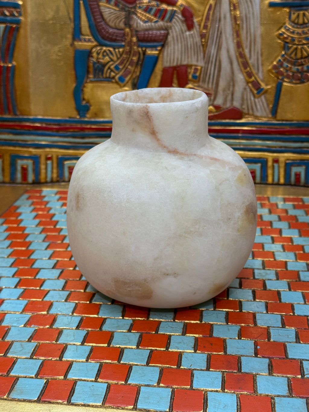 Rounded cream alabaster vase with a short straight neck, delicate warm veins and honey-coloured patches — unlit full view.