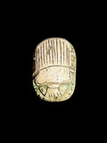 Top view of Egyptian scarab SC-119, showing cream and muted green tones with parallel lines across the wing covers.