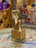 Front angled view of the gold finish Sobek kneeling statue with crocodile head and decorated square base.