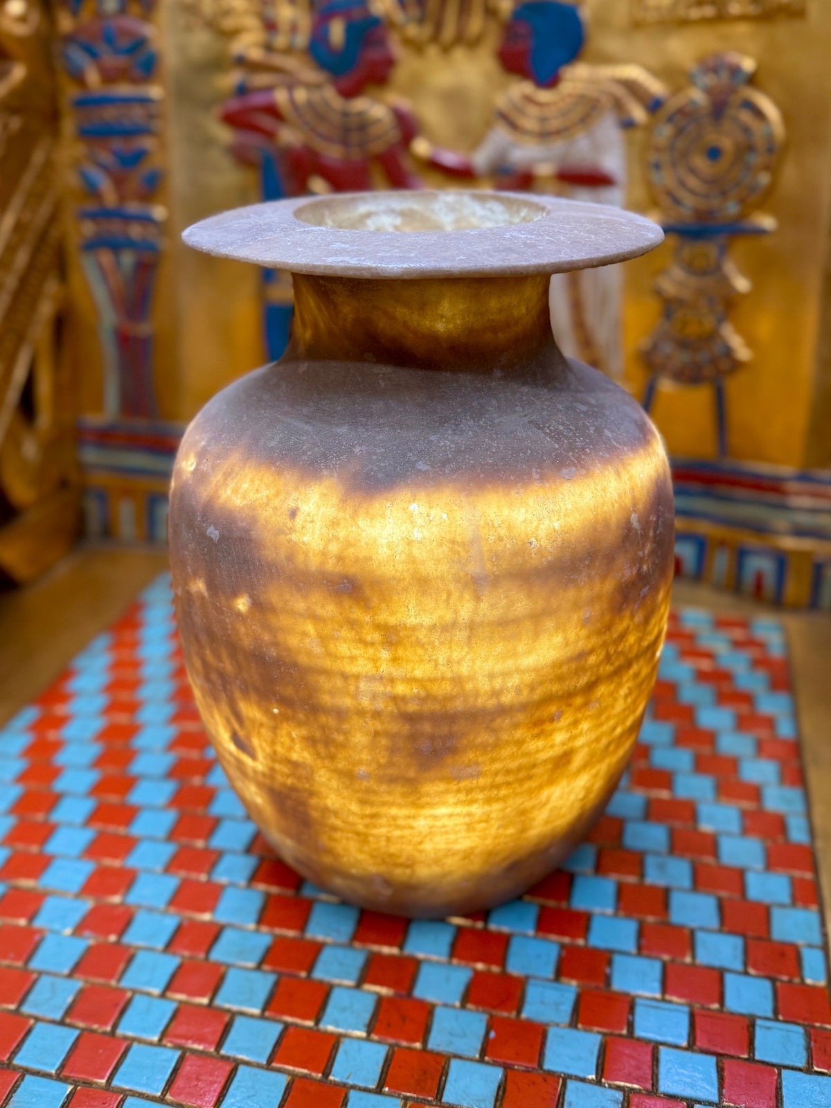 Smoky grey-brown alabaster vase with a tapering body, rounded shoulders and a broad flared rim — illuminated view showing golden bands.
