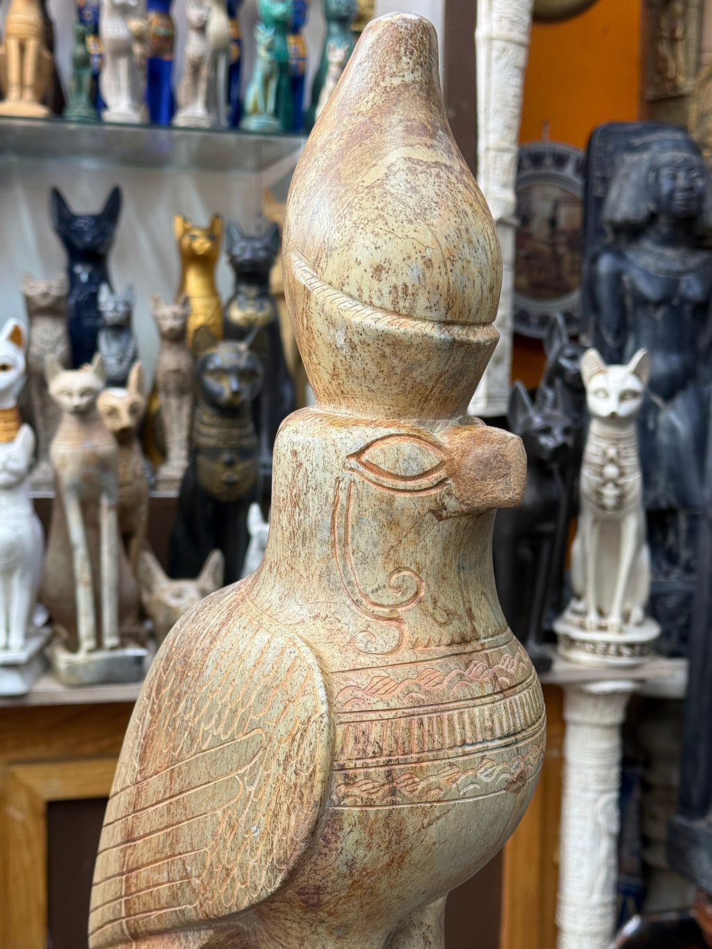Close view of the Horus statue’s crown, outlined eye, curved facial marking and decorative bands across the chest.