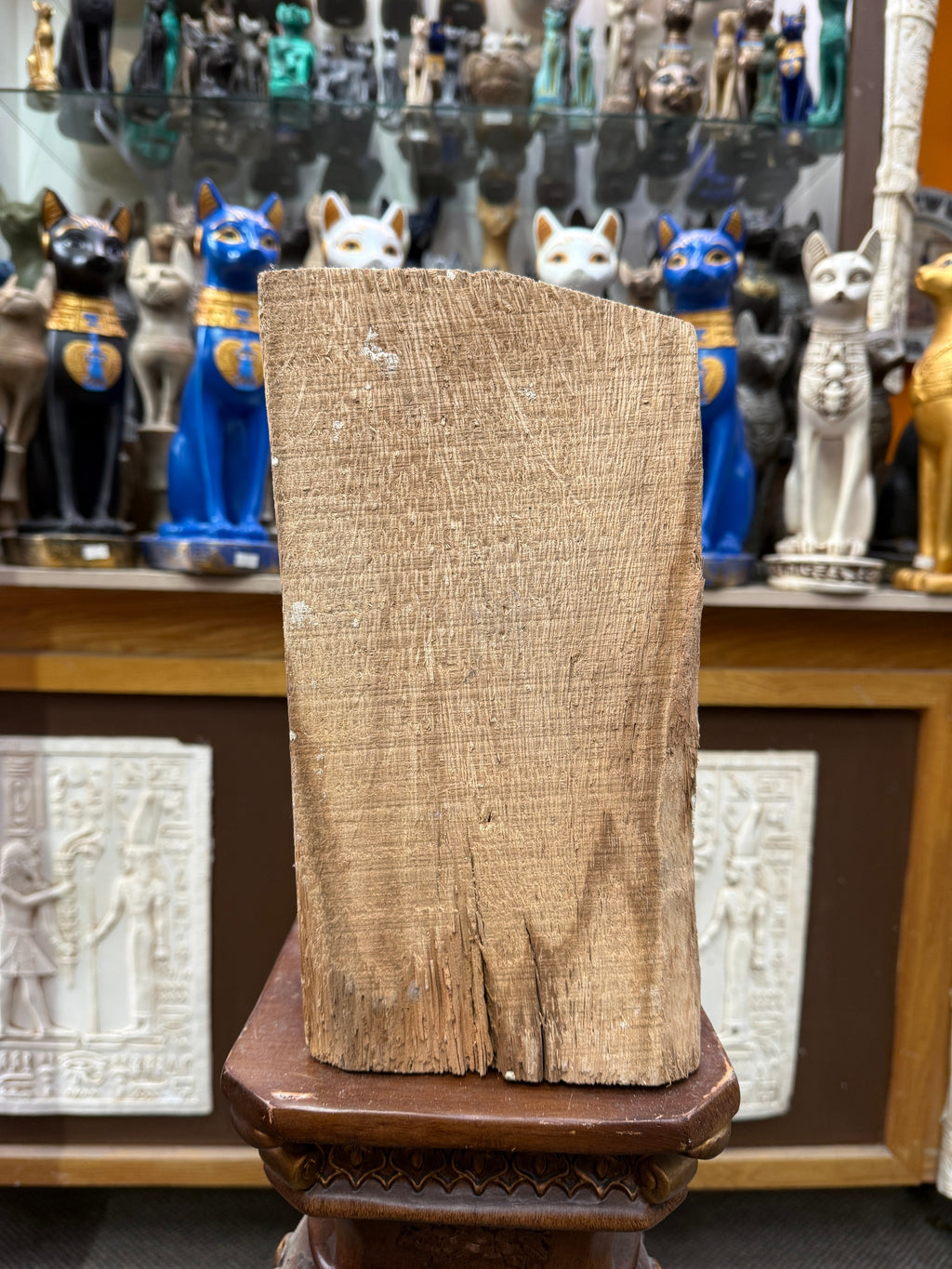 Unpainted back of the Offering to Thoth wood plaque, showing wood grain and a split at the lower edge.