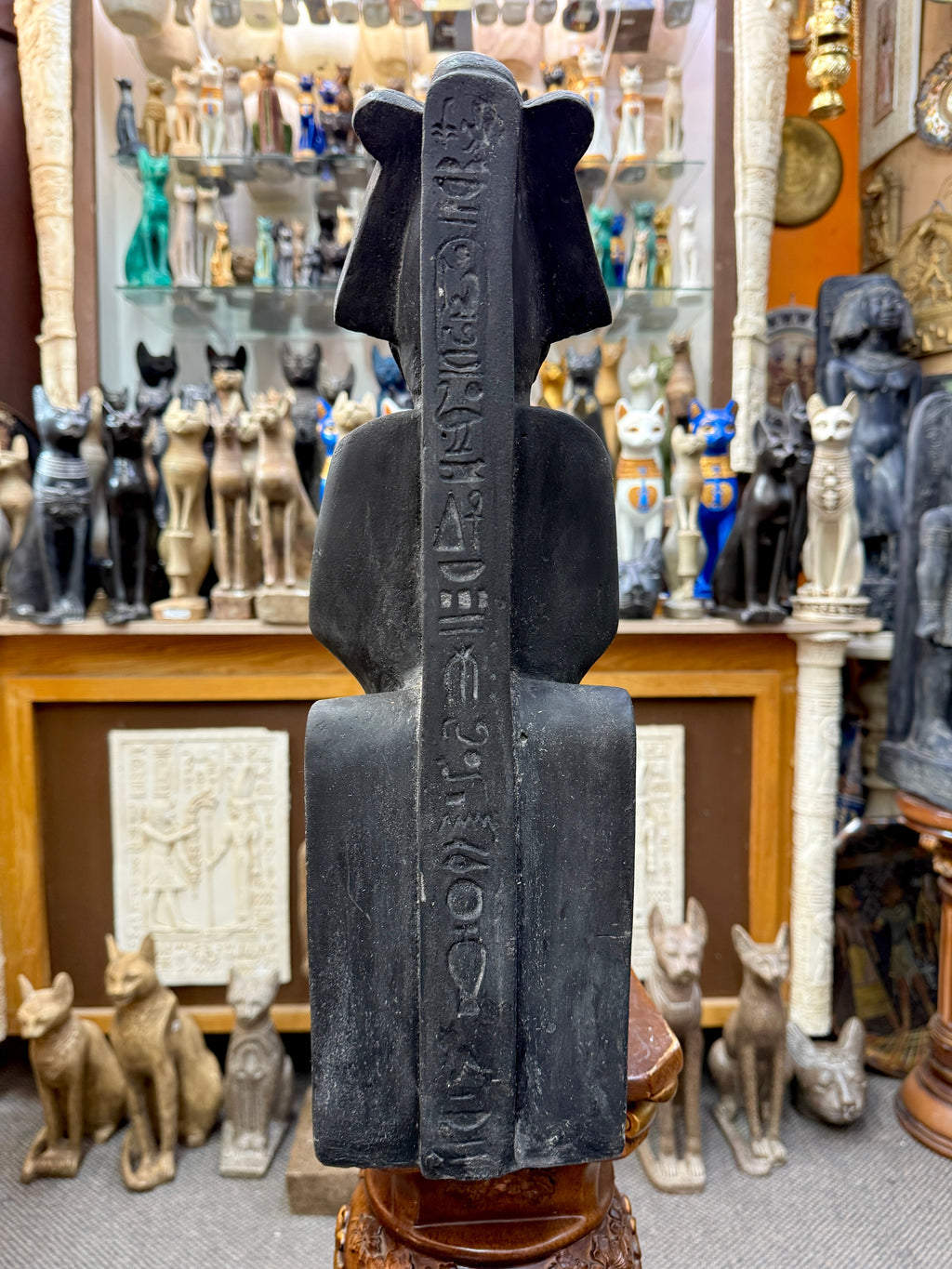 Rear view of the Osiris statue showing a vertical band of hieroglyphic markings along the central support.