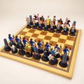 Chinese Dynasties pewter chess pieces arranged on a display chessboard, with opposing dark red and black bases. Board not included.