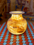 Small rounded alabaster vase with amber-coloured swirls, dark brown veining and a flared rim — full view.