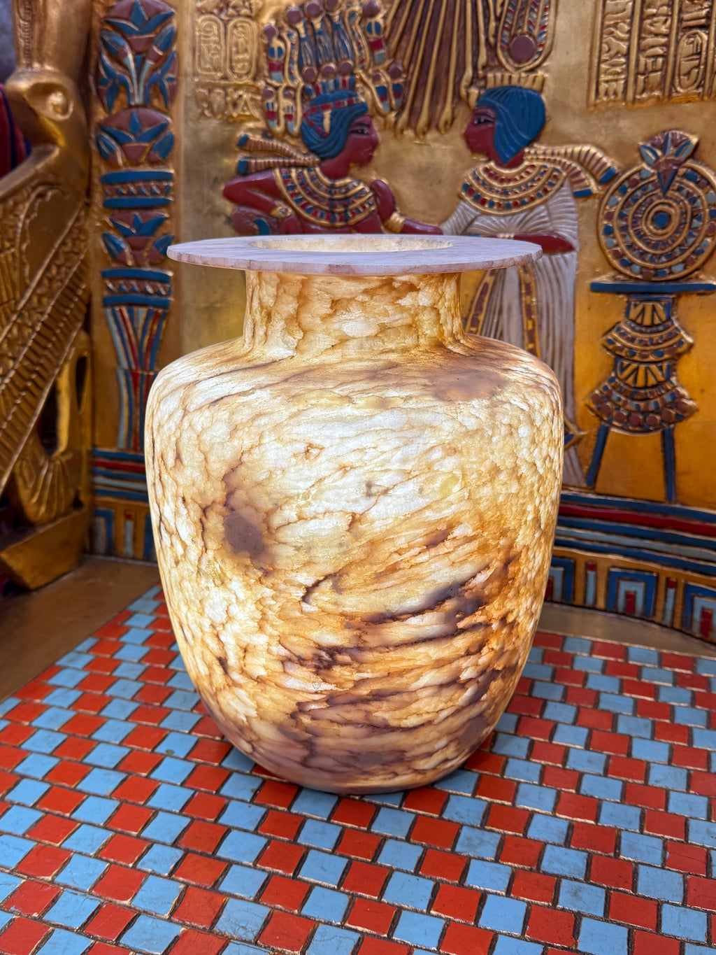 Broad alabaster vase with a low flared neck and layered honey, cream and brown veining — full view.