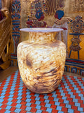 Broad alabaster vase with a low flared neck and layered honey, cream and brown veining — full view.