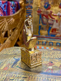 Front angled view of the gold finish Meretseger kneeling statue with cobra head and decorated square base.