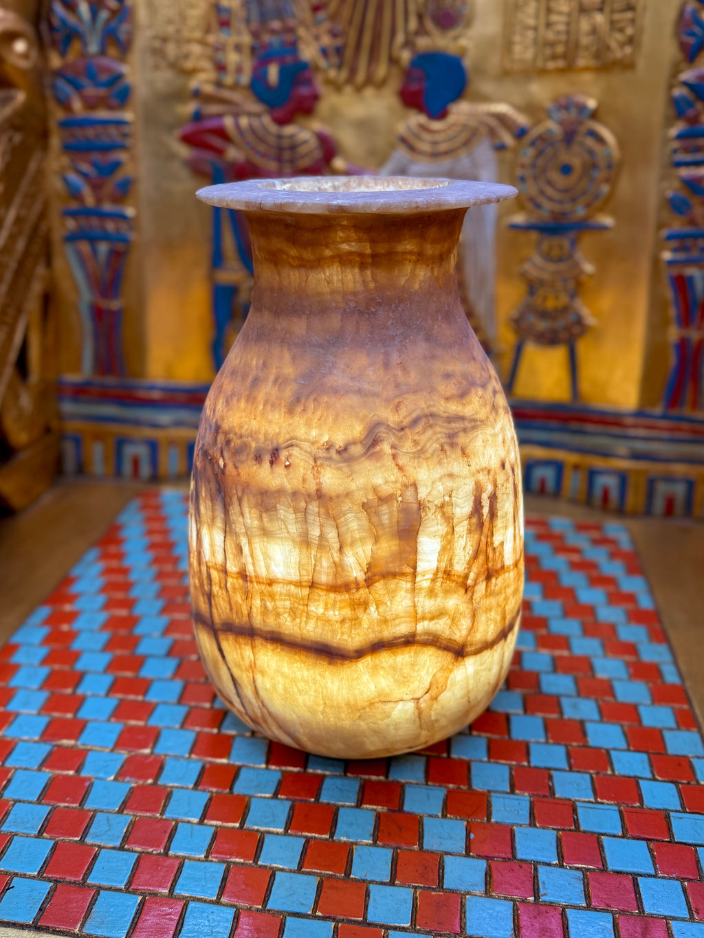 Tall alabaster vase with amber-brown horizontal bands, fine vertical veins and a flared rim — full view.