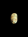 Top view of Egyptian scarab SC-051, showing cream tones with muted green accents.