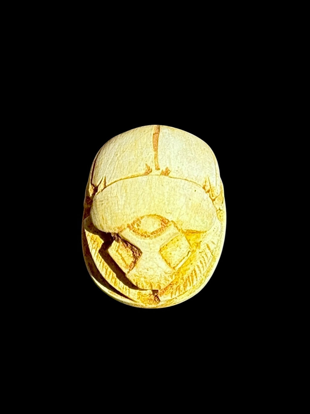 Top view of Egyptian scarab SC-099, showing warm cream and golden tones.
