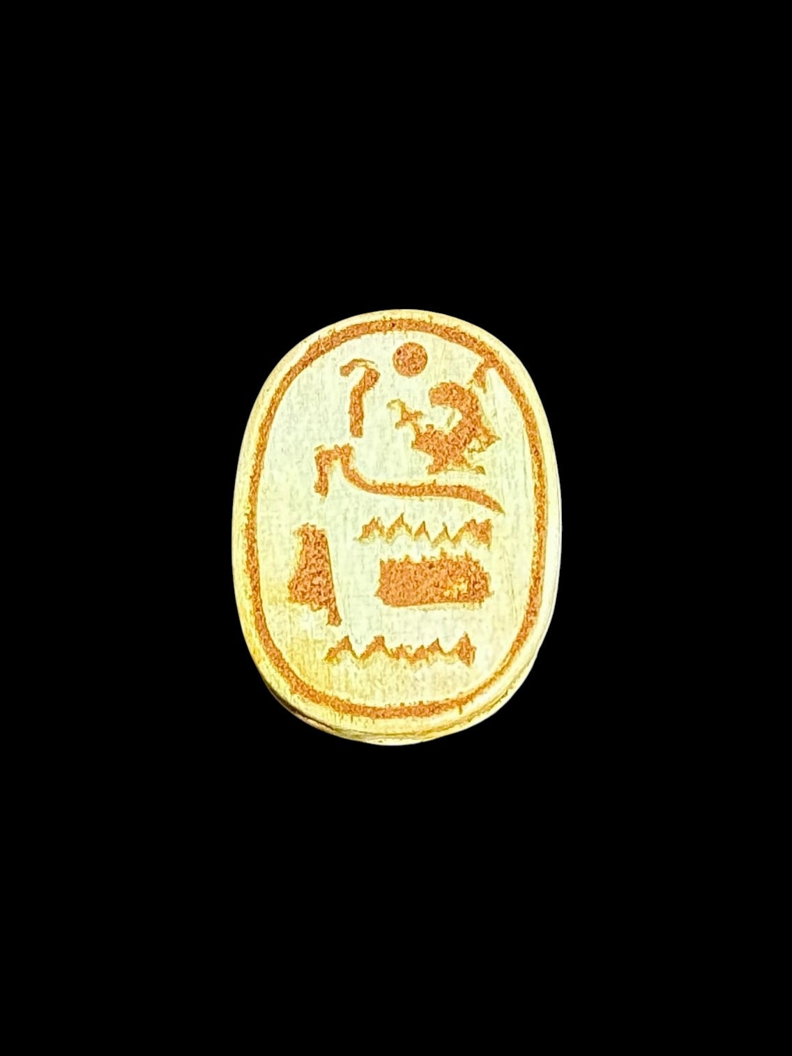 Underside of Egyptian scarab SC-102, showing pale green underside with ochre motifs arranged in several bands.