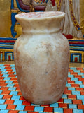 Small curved alabaster vase with cream and taupe markings and a softly flared cup-shaped rim — unlit full view.