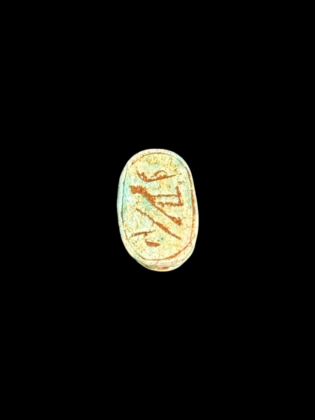 Underside of Egyptian scarab SC-055, showing pale green and cream underside with warm brown markings.