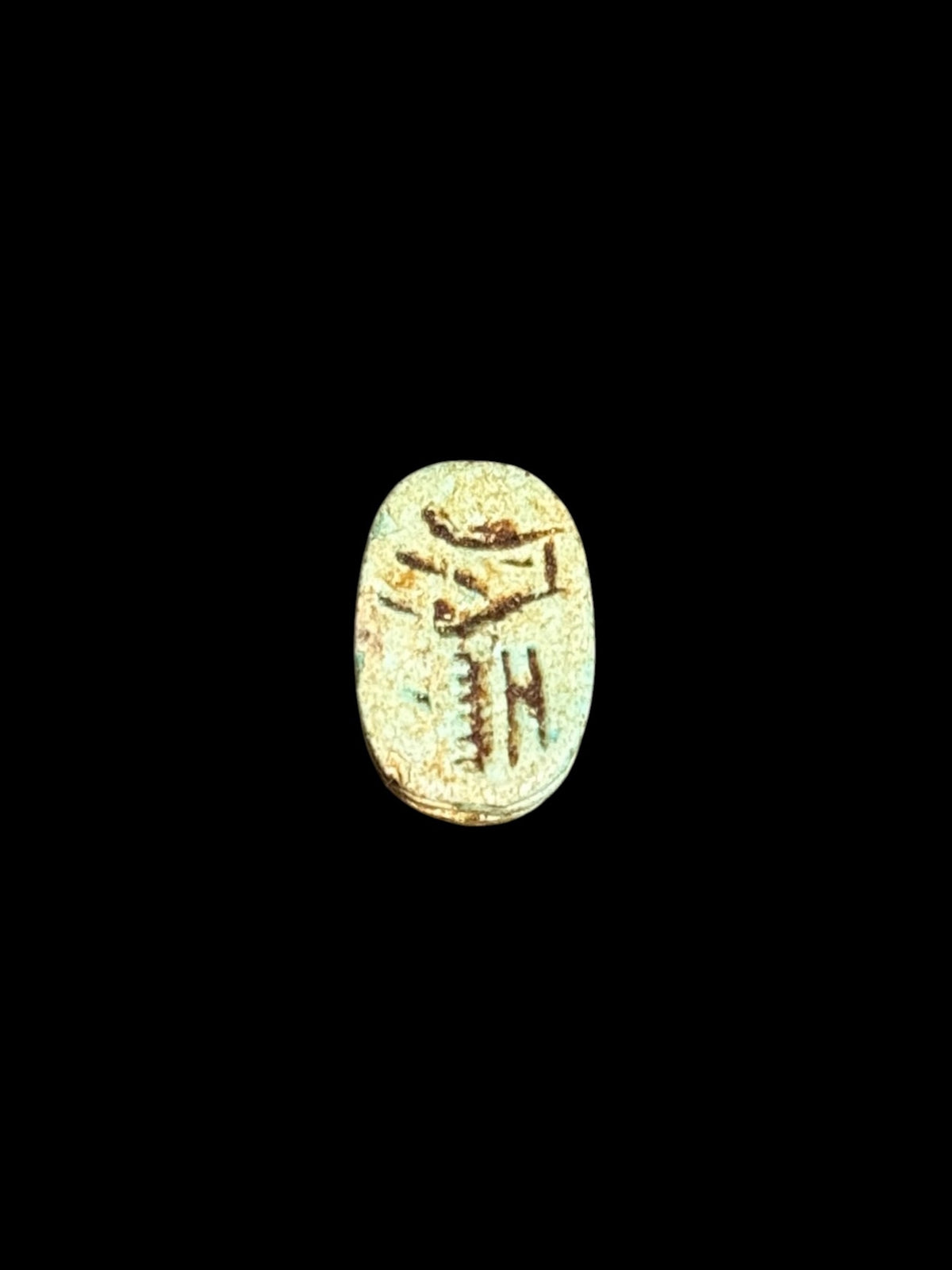 Underside of Egyptian scarab SC-057, showing pale green underside with brown incised markings.