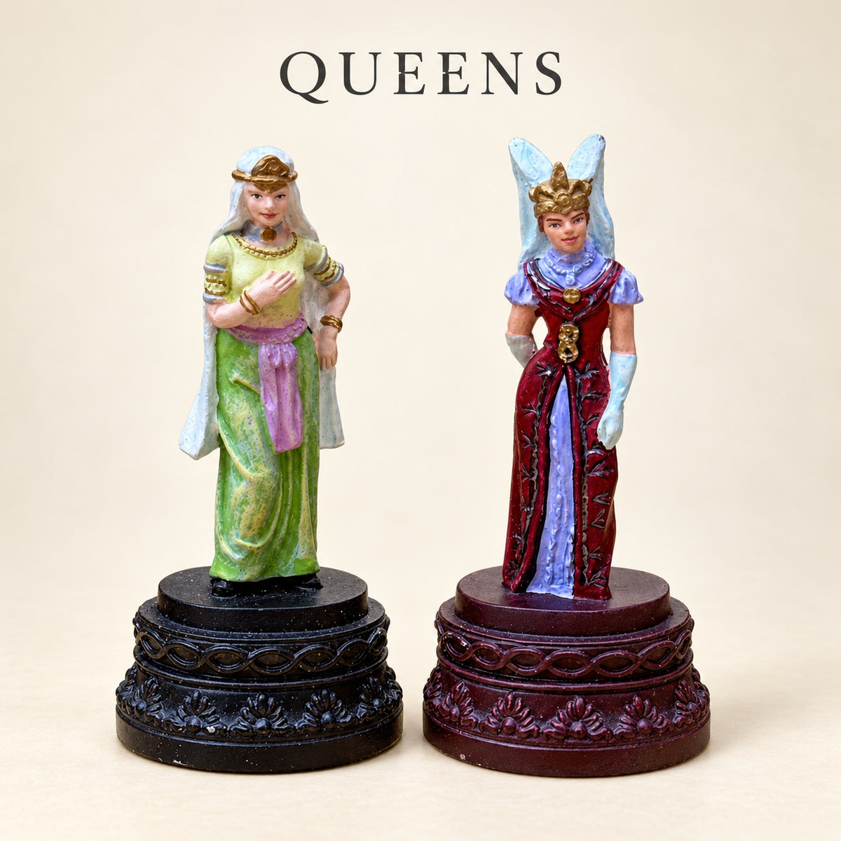 Crusaders vs. Arabs pewter queen pieces in a green gown and a red gown, with contrasting decorative bases.