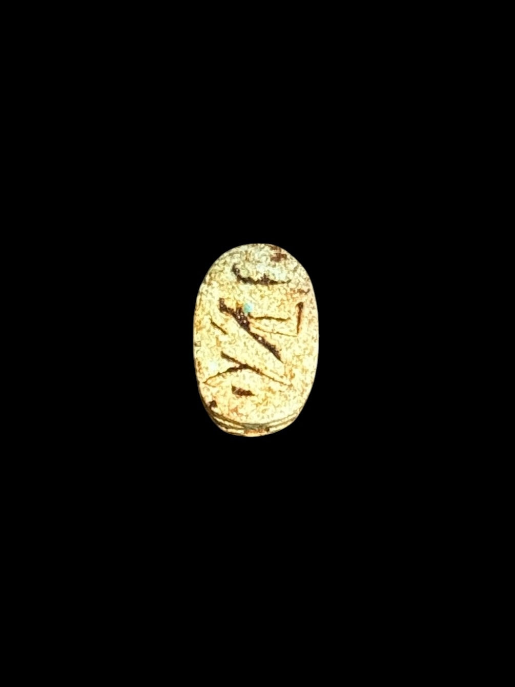 Underside of Egyptian scarab SC-059, showing golden-cream underside with brown incised markings.