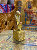 Front angled view of the gold finish Taweret kneeling statue with hippopotamus features and decorated square base.