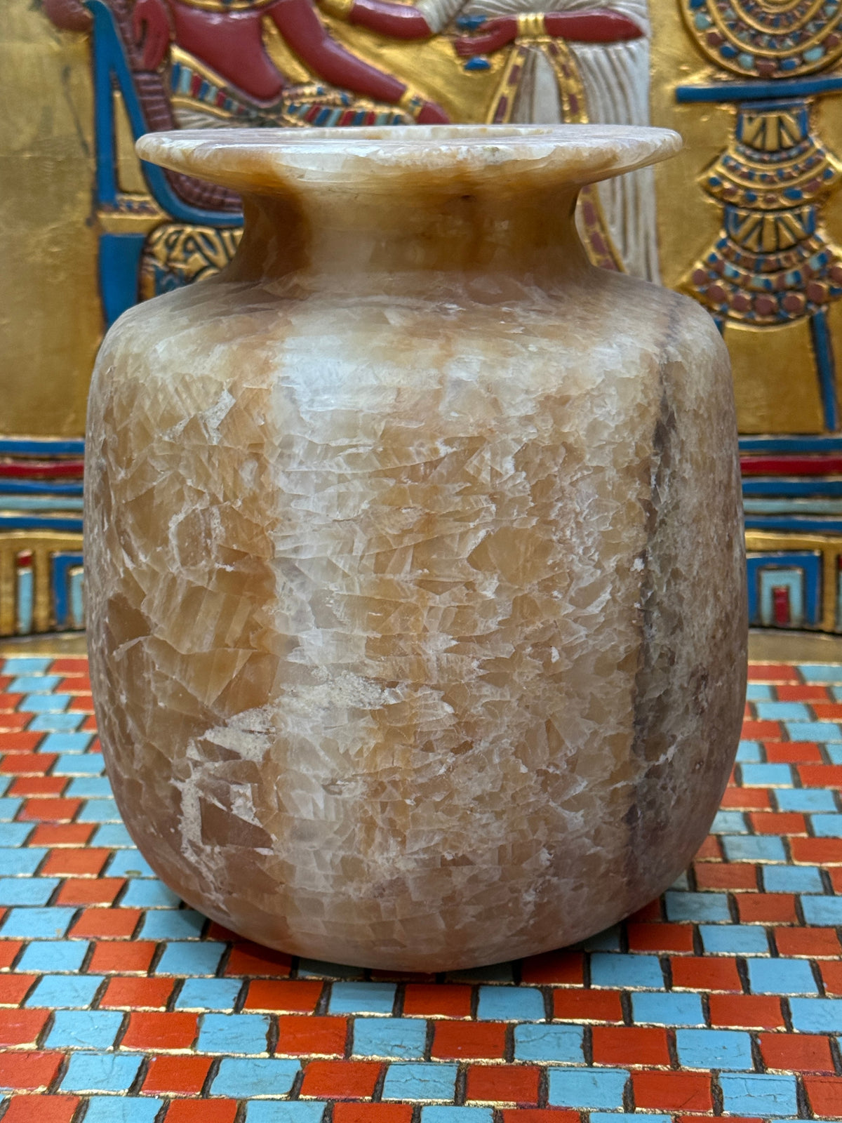 Broad alabaster vase with caramel and cream bands, rounded shoulders and a wide flared rim — unlit full view.