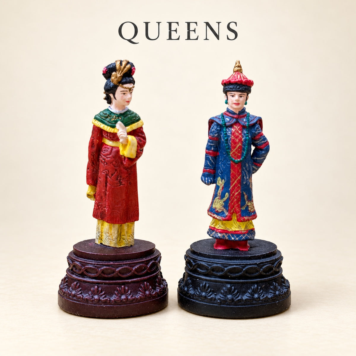 Two Chinese Dynasties pewter queen pieces in colourful robes and ornate headdresses.
