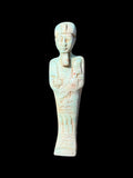 Front view of a pale blue and cream shabti figurine with rounded headdress, ceremonial beard, hands across the torso and incised markings.