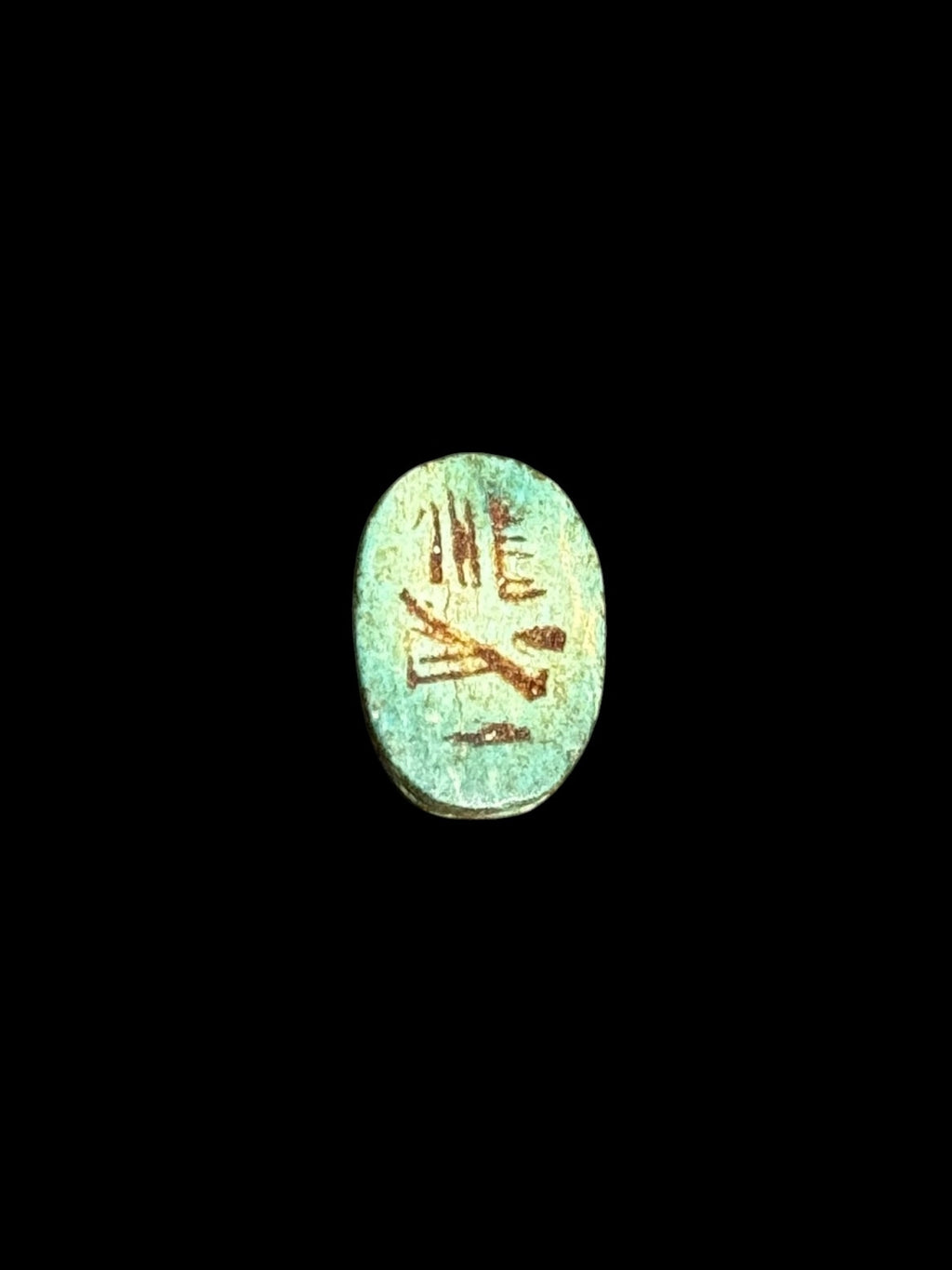 Underside of Egyptian scarab SC-052, showing green underside with darker incised markings.