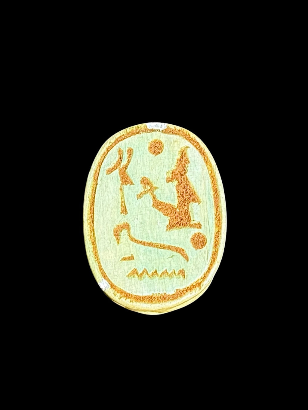 Underside of Egyptian scarab SC-103, showing pale green underside with ochre figures and circular details.