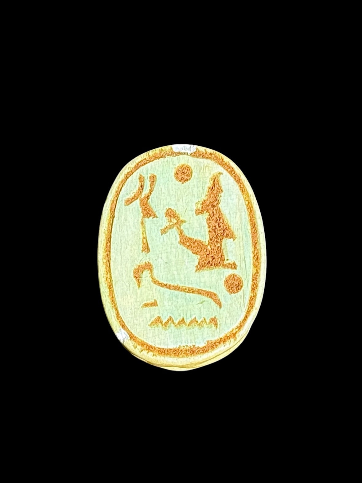 Underside of Egyptian scarab SC-103, showing pale green underside with ochre figures and circular details.