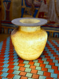 Small golden-cream alabaster vase with a rounded body, short neck and broad flared rim — full view.